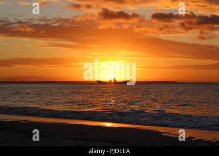 Coucher de soleil sur la plage à Inskip Point, à l'extérieur, vers l'île de Fraser comme un bateau près de l'horizon passe. Banque D'Images