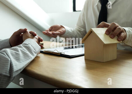 Contrat d'affaires sur le commerce - louer une maison. Hommes d'assurance habitation. Concept d'entreprise. Banque D'Images