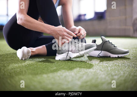 Attacher les lacets femme in gym Banque D'Images