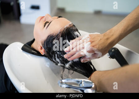 Female client obtenir cheveux lavés par hairstylist dans le salon Banque D'Images