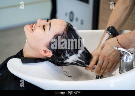 Procédure de Soin en institut de beauté. Coiffure hair brossage est de propager un masque revitalisant traitement ou Banque D'Images