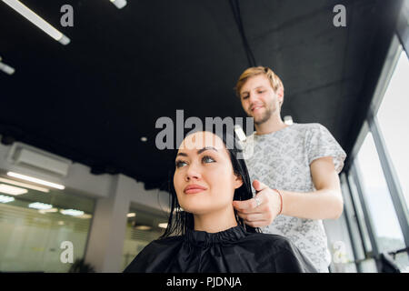 Jeune femme brune et coiffure préparation de coupe ou au salon de beauté coiffure Banque D'Images