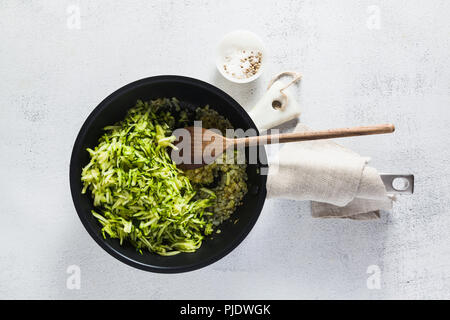 La cuisson du riz avec les courgettes et les oignons dans une poêle. La recette pas à pas de cuisine saine. Banque D'Images