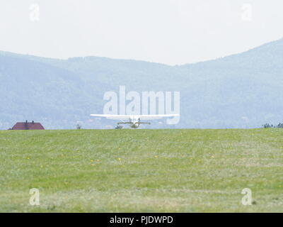 Vue d'avion blanc sport sur des terrains herbeux vert paysages aérodrome, appartient au club de l'air dans la ville de Bielsko-Biala européenne à la Pologne avec bleu clair s Banque D'Images