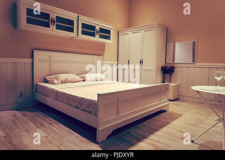 Lit en bois blanc avec des draps blancs. Design intérieur élégant dans des couleurs vives. Cher chambre dans un hôtel 5 étoiles. Banque D'Images