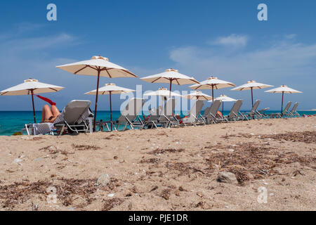 Les touristes bronzer et se détendre sur les chaises longues sur la plage sur l'île de Lefkada, Grèce Banque D'Images