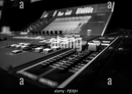 Prise de vue au grand angle de la console de mixage audio professionnel avec encodeur de commande numérique, monochrome, noir et blanc Banque D'Images