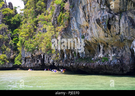 Les touristes d'explorer avec les roches calcaires érodés en canoë dans la baie de Phang Nga, la Thaïlande, l'Touristen erkunden mit dem Kanu erodierte Kalksteinfelsen dans Banque D'Images