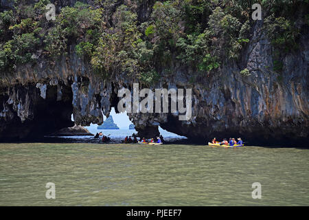 Les touristes d'explorer avec les roches calcaires érodés en canoë dans la baie de Phang Nga, la Thaïlande, l'Touristen erkunden mit dem Kanu erodierte Kalksteinfelsen dans Banque D'Images