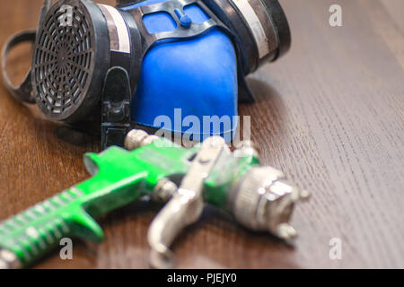 Outils pour la peinture. Un masque respiratoire, des gants, un pistolet. Banque D'Images