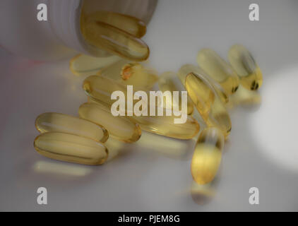 Soft focus de l'huile de poisson Omega capsules de gel de renversé une bouteille de pilules. Vitamines et suppléments pour la santé et le bien-être. Banque D'Images