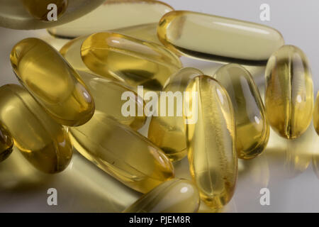 L'huile de poisson Omega Capsules Gel jaune close up. Suppléments poissons renversé sur une table. Les suppléments de soins de santé isolés. Banque D'Images