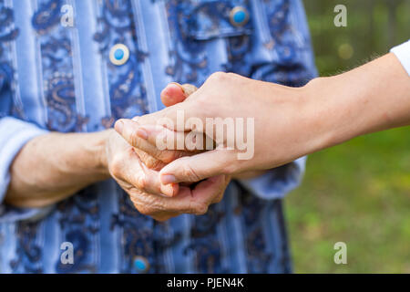 Photo Close up of young woman holding sa grand-mère, les mains ridées Banque D'Images