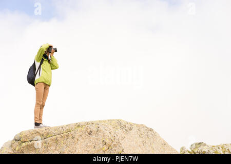 Sur un rocher photographe de prendre une photo avec fond de nuage Banque D'Images