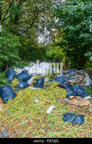 Dépotoir sauvage sur un terrain de stationnement public, l'élimination illégale de déchets de construction, déchets de câbles, à grande échelle, la poubelle a été déposée plus tard f Banque D'Images