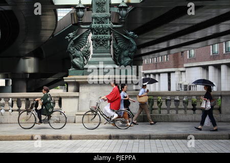 Piétons et cyclistes passent des statues de dragons sur pont Nihonbashi. Le Shoto Expressway est au-dessus du pont. (Juin 2018) Banque D'Images