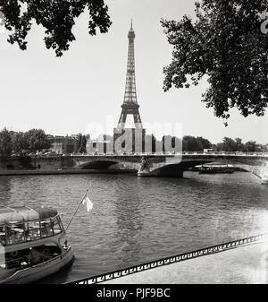 Années 1960, historique, vue sur la Seine à Paris et dans la distance, la célèbre Tour Eiffel, un pylône en treillis en fer forgé, 300 mètres de haut, construite en 1889 et l'une des ville les plus emblématiques des structures. Banque D'Images