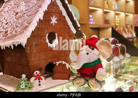 Décorations de Noël avec Mignon Doudou éléphant en costume de Père noël et bonhomme de massepain en face de Gingerbread House Banque D'Images