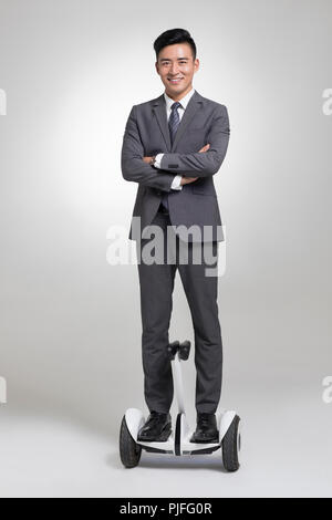 Certains jeunes businessman riding segway Banque D'Images