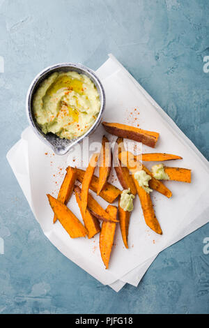 Trempette à l'avocat dans un bol d'épices et pommes de terre sur la table. Vue de dessus. Concept Alimentation saine Régime propre Banque D'Images