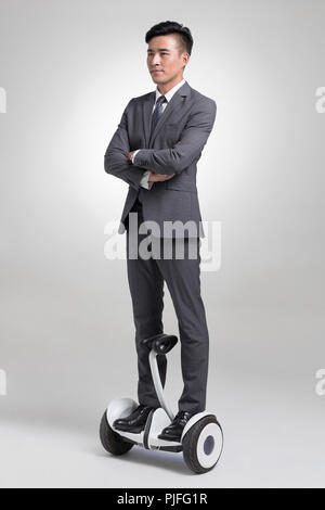 Certains jeunes businessman riding segway Banque D'Images