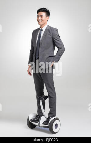 Certains jeunes businessman riding segway Banque D'Images