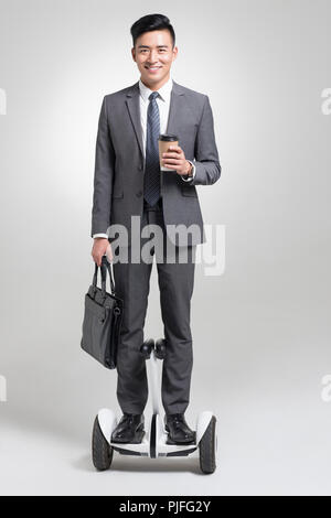 Certains jeunes businessman riding segway Banque D'Images