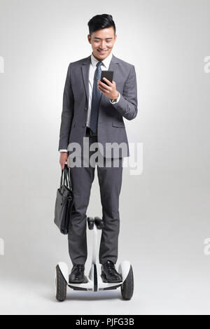 Certains jeunes businessman riding segway Banque D'Images