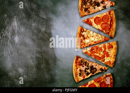 Tranches de pizza avec des obturations différentes sur un fond texturé noir, vue du dessus Banque D'Images