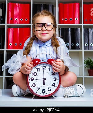 Cute little girl portant des lunettes avec une horloge Banque D'Images