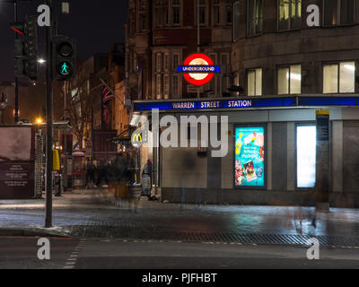 Londres, Angleterre, Royaume-Uni - 27 Février 2018 : Les piétons marcher le long de la rue du même nom à l'extérieur de la station de métro Warren Street la nuit. Banque D'Images