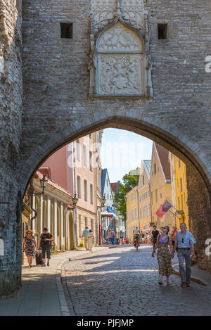 Voir des gens marcher sous la voûte de la grande porte de la côte sur la rue Pikk sur le côté nord de la vieille ville médiévale de Tallinn, Estonie. Banque D'Images