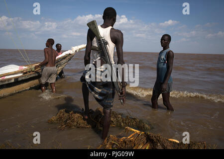 Les pêcheurs kenyans armés se préparer à naviguer leur bateau pendant une expédition de pêche sur le lac Turkana, au nord du Kenya, le 4 novembre 2012 Banque D'Images