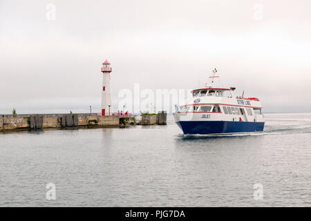 Les touristes sur un ferry près de l'embarcadère de Saint Ignace au Michigan. Wawatom phare sur la jetée. Banque D'Images