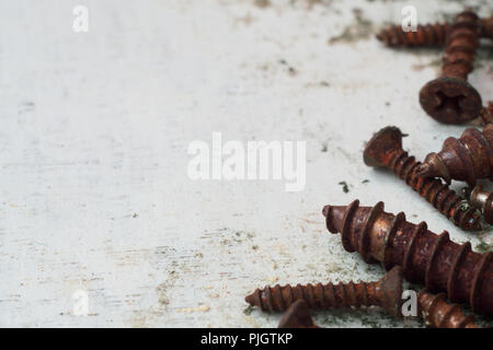 Close up portrait of rusty vis. ancien de boulons en acier sur fond de bois blanc grunge Banque D'Images