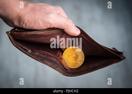 Dans la pièce de bitcoin wallet brun cuir. e-Commerce concept. Faire de l'argent sur l'exploitation minière. Homme mains tenant un sac à main. Homme manières et bitcoin. Banque D'Images