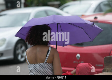Les refuges d'une femme de la pluie sous un parapluie la pluie commence à tomber dans le nord de Londres. Le Met Office a publié un réchauffement de la météo avec des orages susceptibles de tout le Londres et sud-est de l'Angleterre à partir de 15h00 jusqu'à 3h du matin demain (mercredi) après quelques mois de la canicule. Avec : Atmosphère, voir Où : London, Royaume-Uni Quand : 07 août 2018 Credit : Dinendra Haria/WENN Banque D'Images