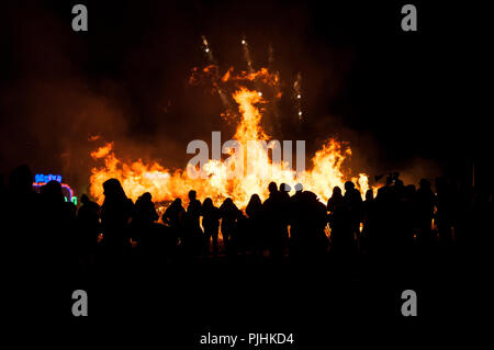 Les gens sont silhouetté contre les flammes d'un grand feu de joie le 5 novembre, la nuit de Guy Fawkes, Bonfire Night. Banque D'Images