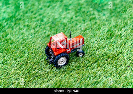 Jouet miniature tracteur sur faux gazon Banque D'Images