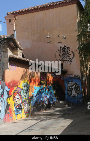 Plaka Athènes Grèce Scène de rue graffitis sur les murs des bâtiments et des chaussures haute suspendus sur le fil Banque D'Images