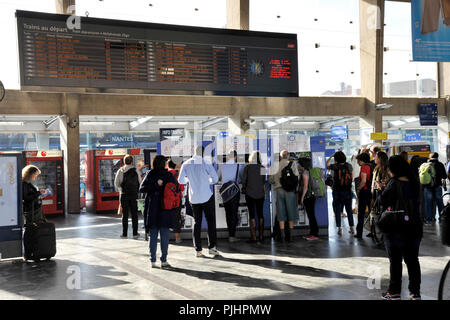 France, Nantes, les voyageurs dans le hall des départs de la gare, les gens d'acheter des billets au ticket machine terminaux. Banque D'Images