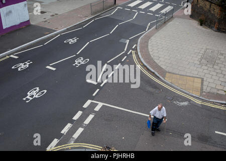 Un homme âgé a du mal à traverser la route près du bientôt-à-être démoli Aylesbury Estate, le 4 septembre 2018, à Southwark, Londres, Angleterre. L'Aylesbury Estate contenait 2 704 logements en 7500 environ habitants et construit entre 1963 et 1977. Il y a des problèmes majeurs avec les bâtiments sur le domaine et la mauvaise perception des successions en Grande-Bretagne dans son ensemble ont conduit à l'Aylesbury Estate gagner le titre d'un des plus fameux estates au Royaume-Uni. Banque D'Images