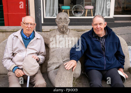 L'Espagne, la Galice, La Corogne, Avenida Pio XII, Prazo ne l'humour, les touristes handicapés et s'est assis à côté de la sculpture sur un banc de pierre sculptée Banque D'Images