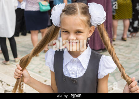 Lycéenne au festival le 1 septembre détient ses longs cheveux dans ses mains Banque D'Images