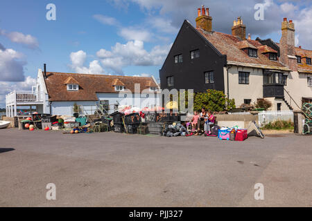 Une femme et deux petites filles s'asseoir parmi les pots de stockage de pêche sur Mudeford Quayside, Dorset, UK Banque D'Images