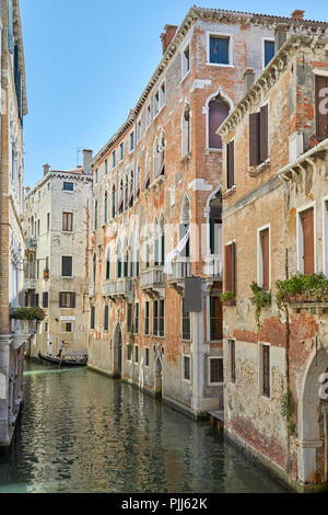 Venise, Italie - 13 août 2017 : anciens bâtiments en brique et canal avec gondola passant par une journée ensoleillée à Venise, Italie Banque D'Images