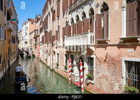 Venise, Italie - 13 août 2017 : Ancien bâtiment de brique et canal avec gondola passant par une journée ensoleillée à Venise, Italie Banque D'Images