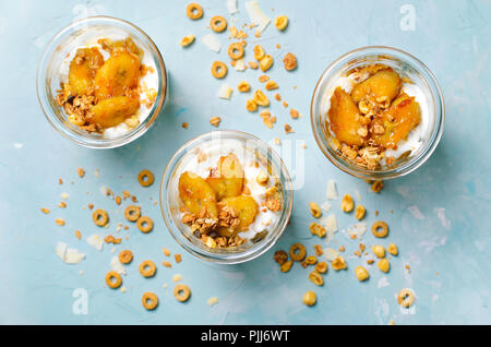 Parfait Glacé à la banane caramélisée et granola, yogourt Dessert maison, petit-déjeuner sain Banque D'Images