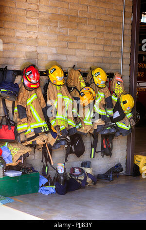 Uniformes de pompiers et les femmes accroché au mur à l'intérieur d'une caserne à Tucson, AZ Banque D'Images