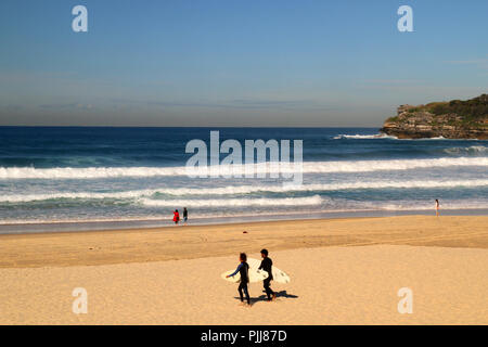 Plage de sable naturel à Sydney, des vagues énormes et deux surfeurs de marcher avec leur surf à l'eau, l'océan Pacifique, la plage de Bondi en Australie Banque D'Images